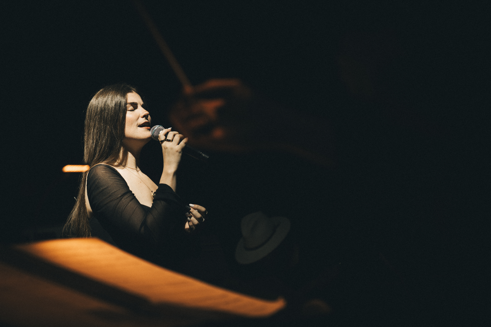 Vocalist Zoe singing in intimate stage lighting